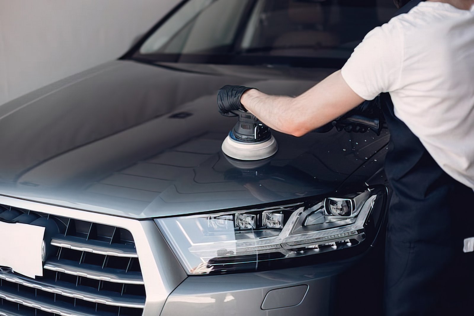 Technician machine polishing a bonnet during paint correction