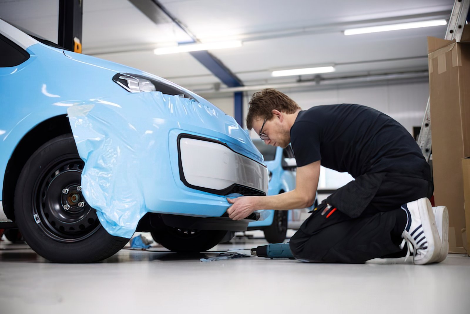 Two technicians applying a PPF wrap in the studio