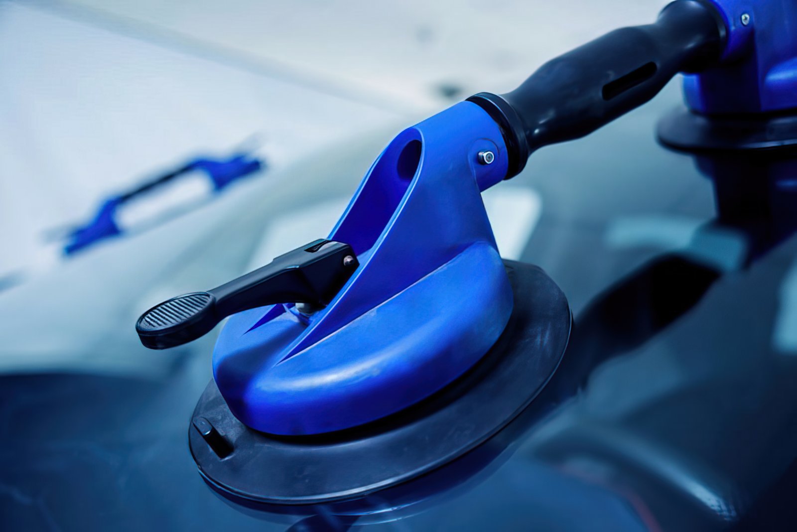 Applying window film with a suction tool to a vehicle window